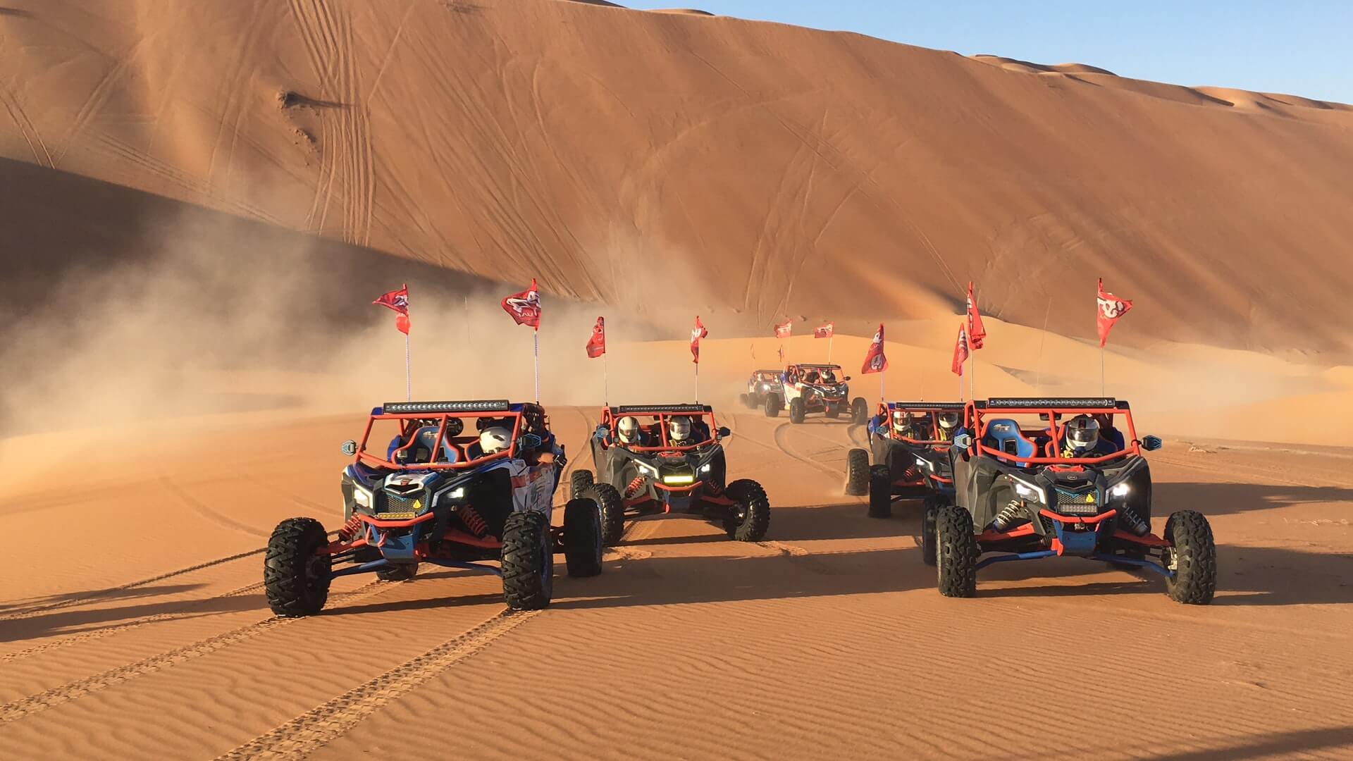 Four wheel drive vehicles crossing desert dunes